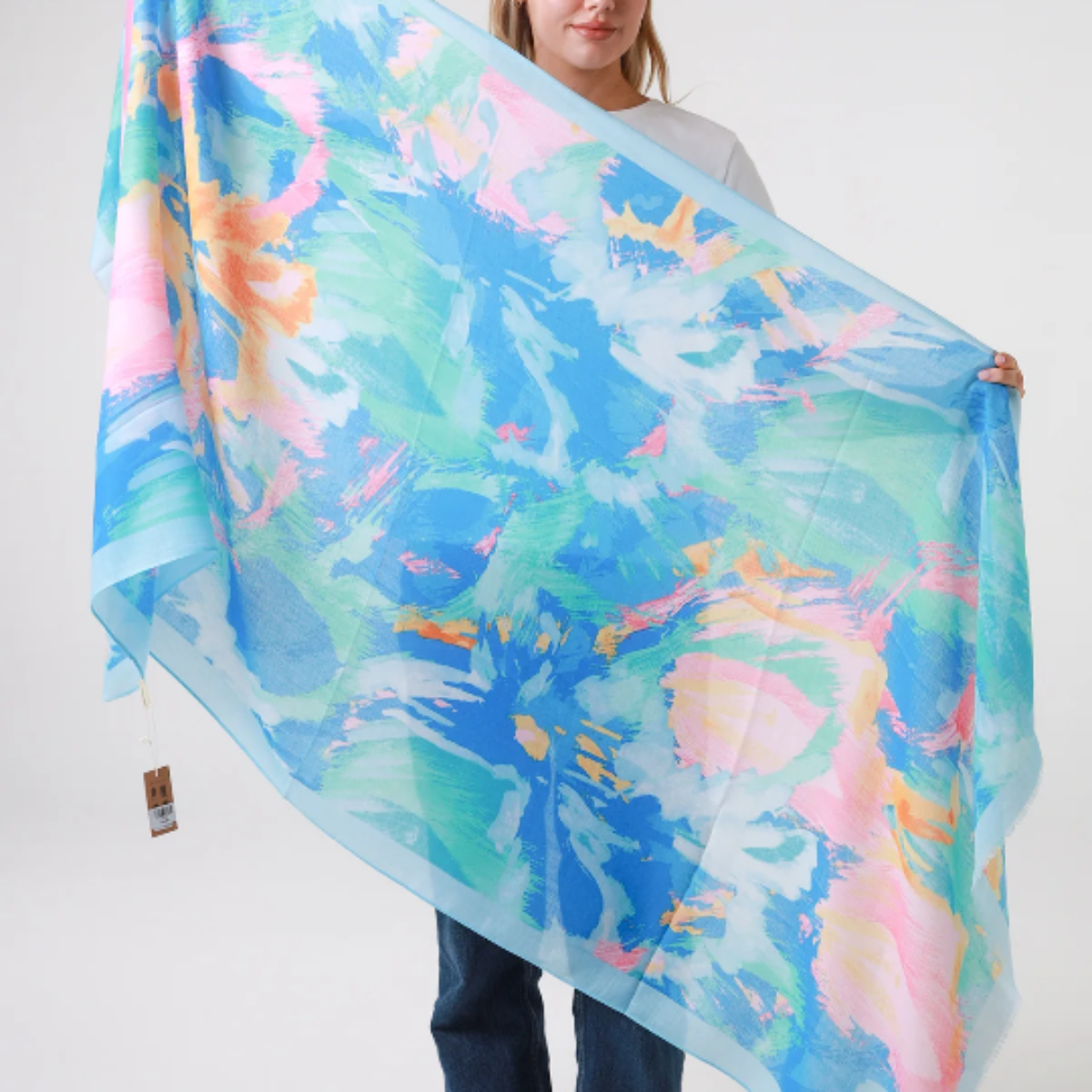 Person holding a colorful scarf with a watercolor design on a white background