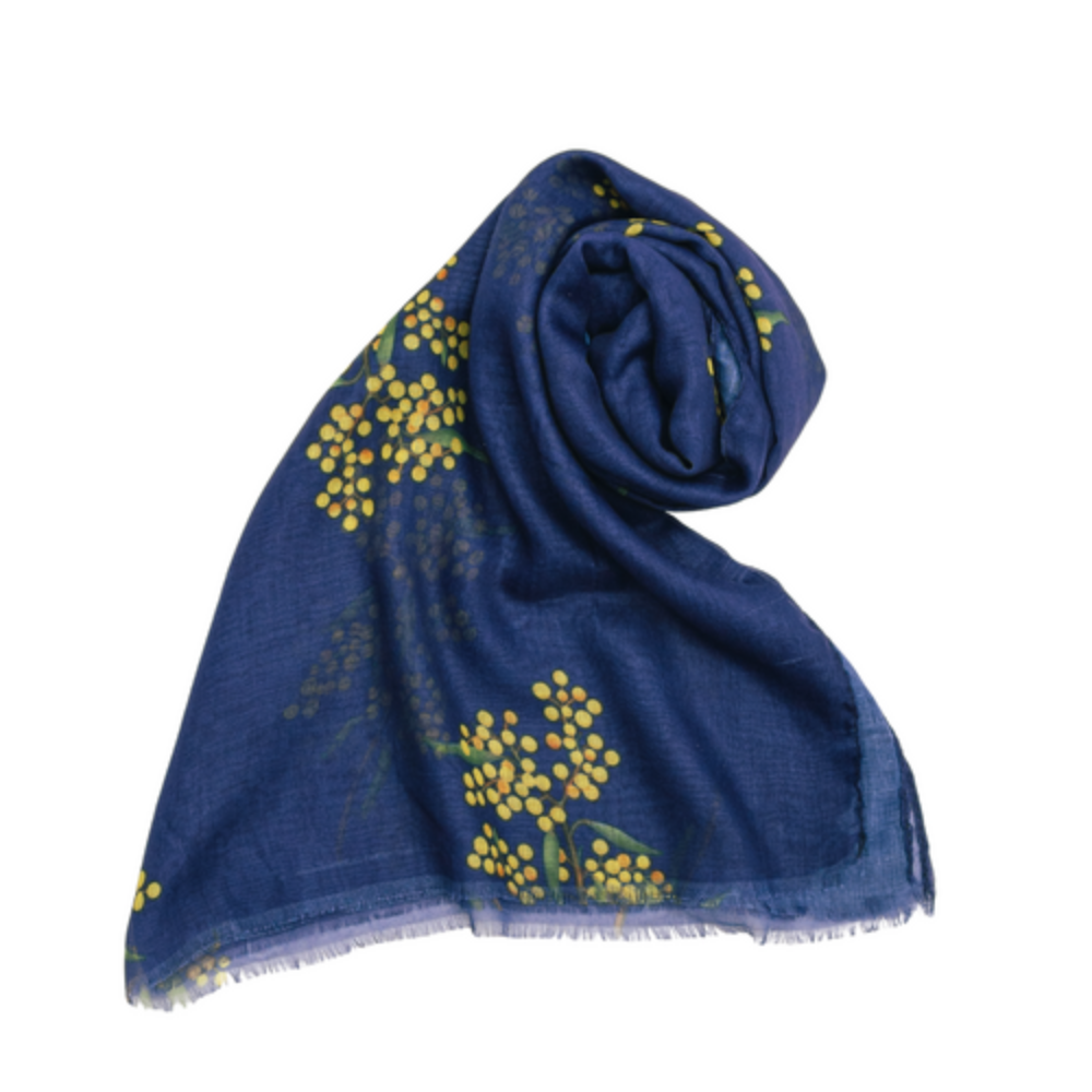 a lightweight cotton scarf that has a navy blue background and bunches of yellow Wattle flowers with green leaves.