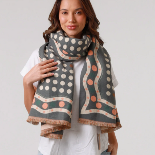 Woman wearing a grey patterned scarf on a plain background