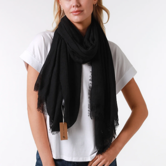 a lady wearing a plain black scarf that has a textured weave and a frayed edge on all sides
