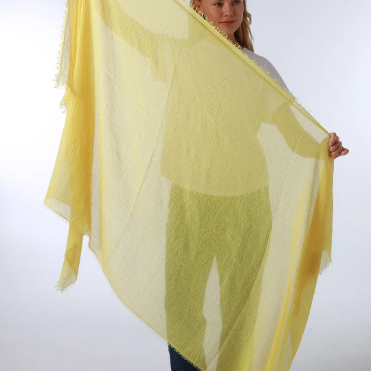 Woman holding a yellow scarf against a white background