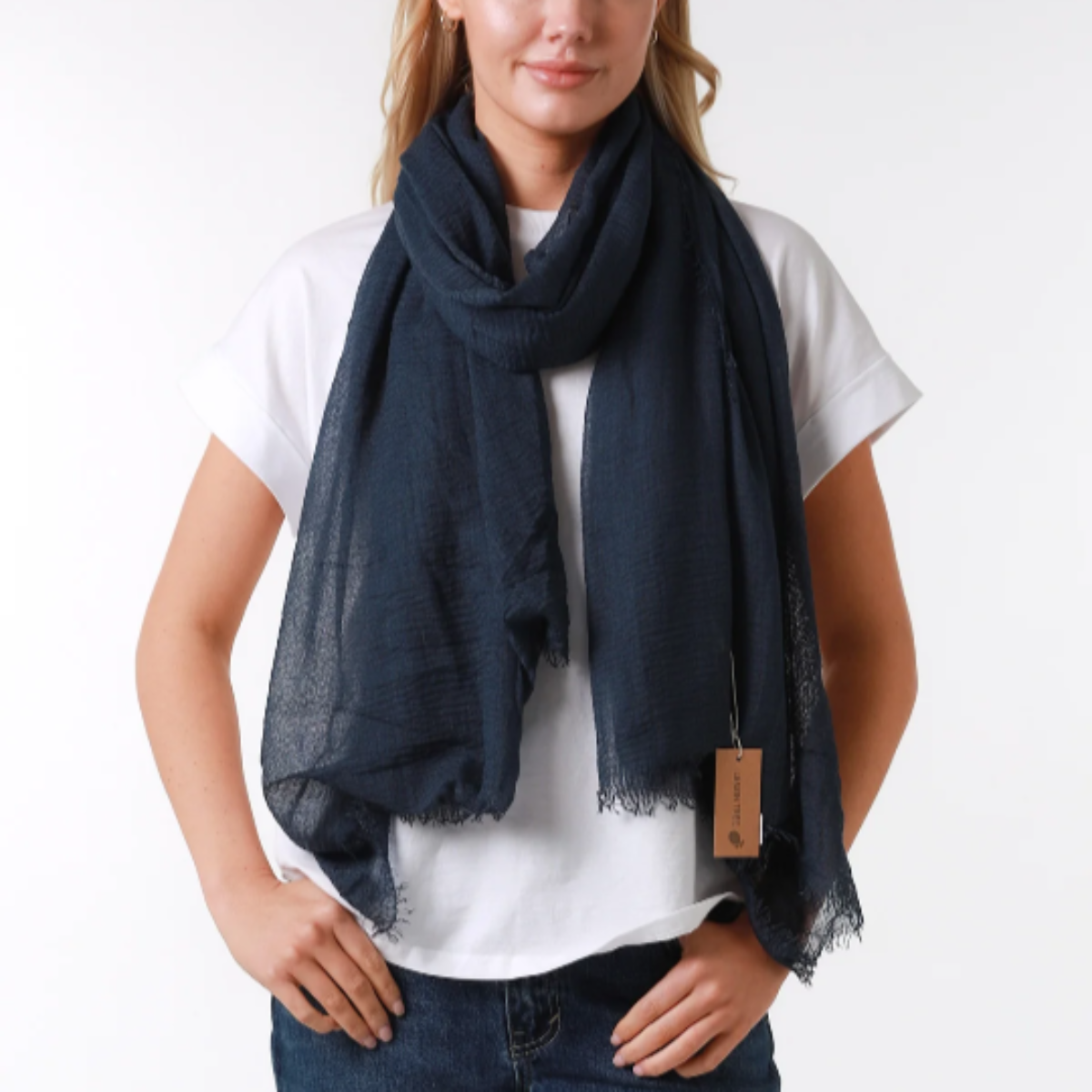 a lady wearing a plain navy blue scarf that has a textured weave and frayed edges on all sides.
