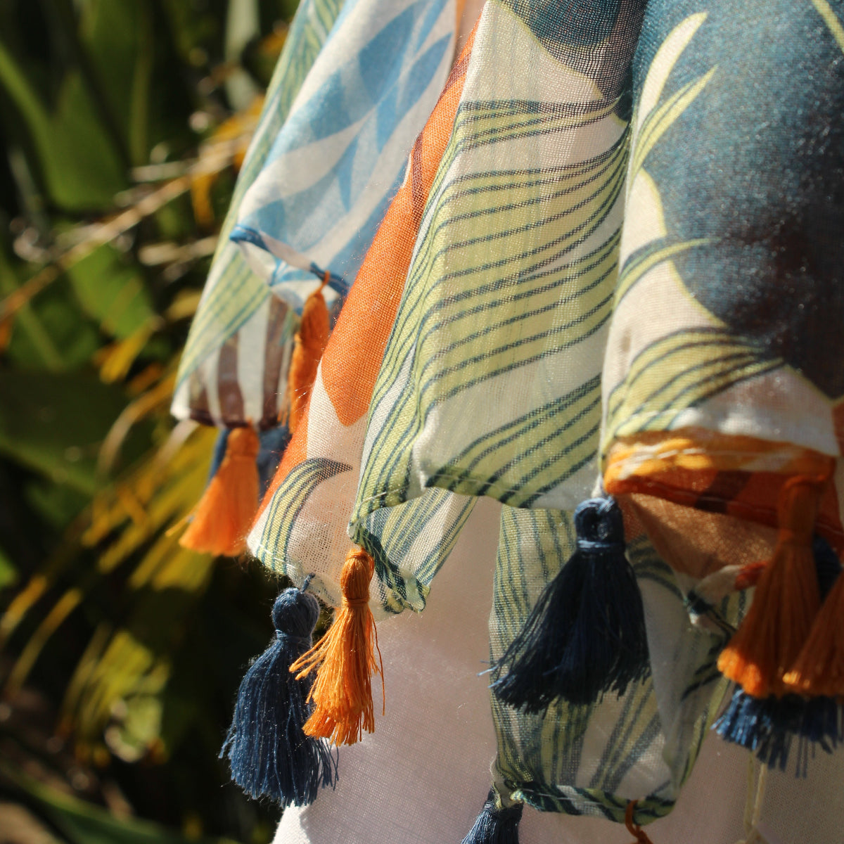 Colorful fabric with tassels on a blurred natural background