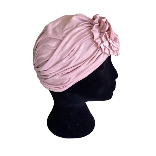 side view of a pink hair turban on a black head mannequin
