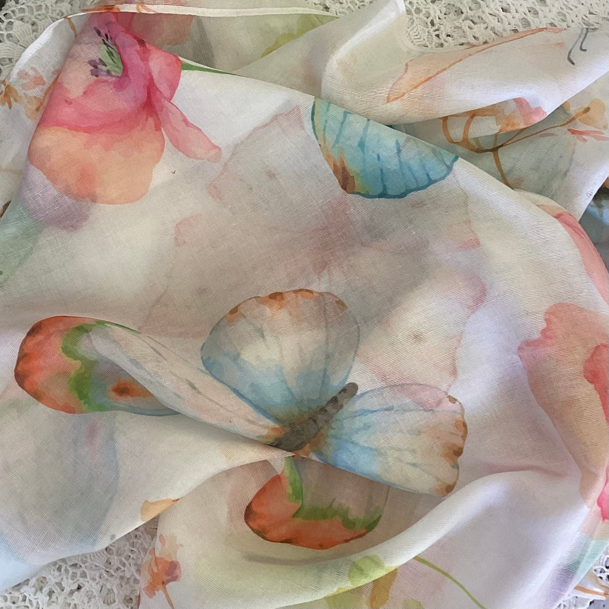 Close-up of a scarf with a watercolor butterfly and floral pattern