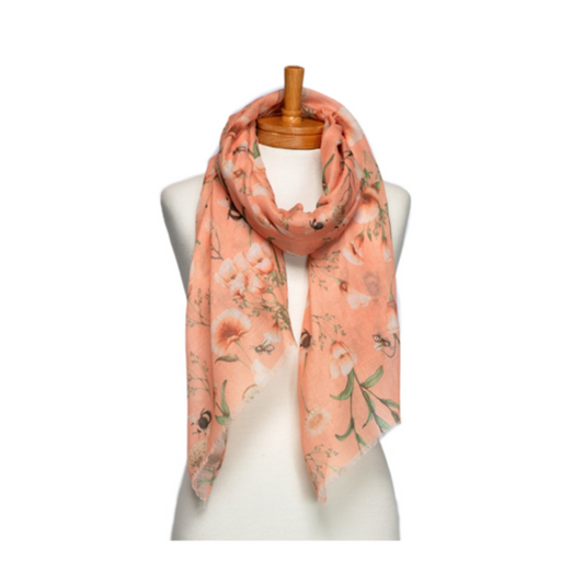 a pretty ladies scarf that has apricot coloured flowers on an apricot coloured background and gumble bees amongst the flowers