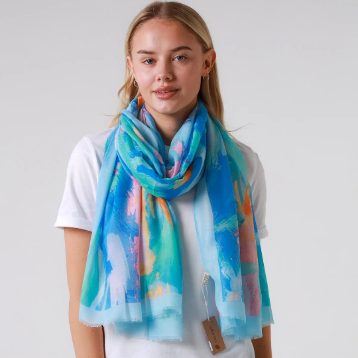 Woman wearing a colorful scarf with a plain background