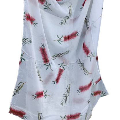 White scarf with red floral pattern draped 