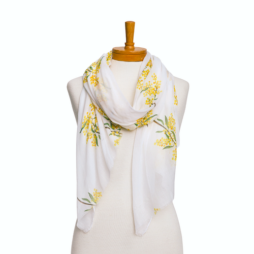 a ladies scarf on a mannequin that has a plain white background and a pattern of yellow Wattle flowers and leaves.