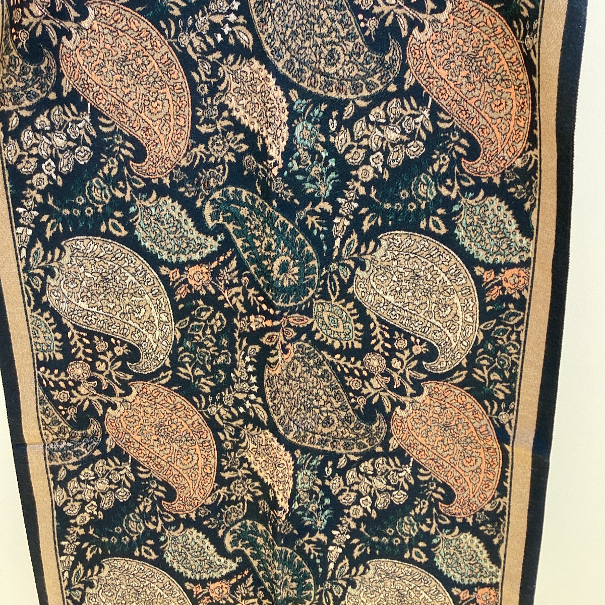 Close-up of a patterned scarf that has a paisley design on a black background