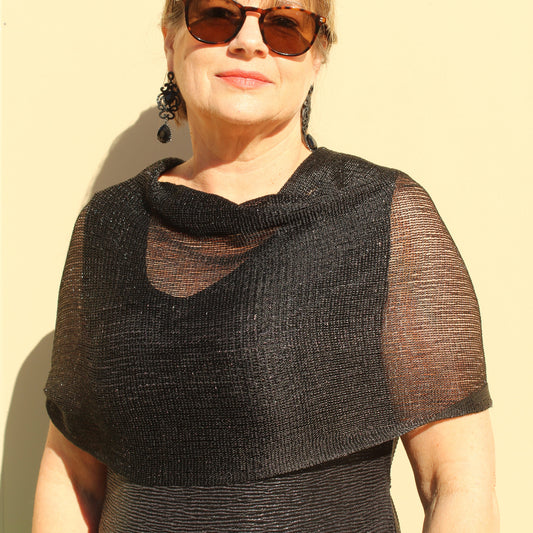 a lady wearing sunglasses, a black evening dress and a sparkly black shawl that has glitter and tassels