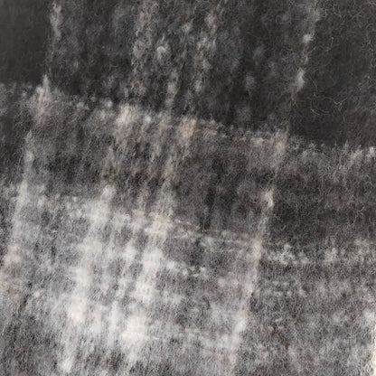 Close-up of a textured ladies chunky scarf in black and white plaid pattern.