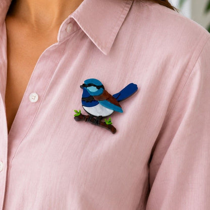 a lady wearing a pink shirt with an acrylic brooch in the shape of a blue wren sitting on a branch