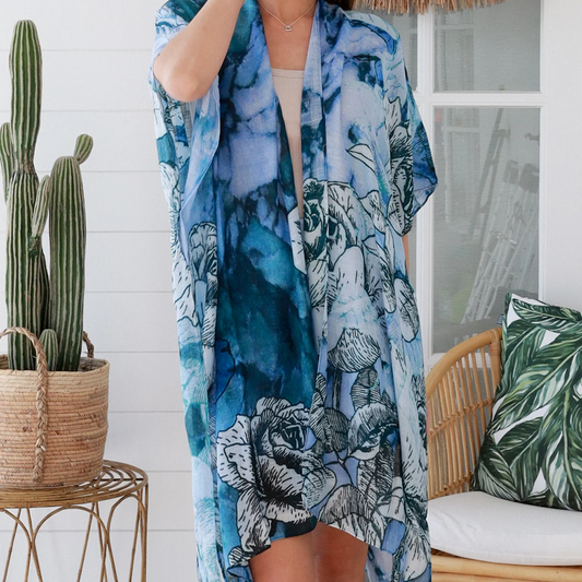 Woman wearing a blue floral kimono with a cactus plant and chair in the background