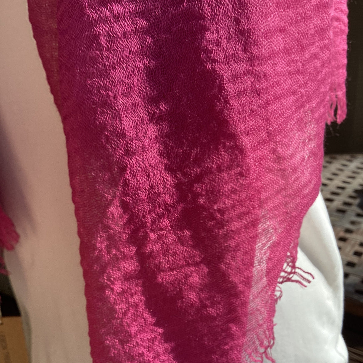 Close-up of a pink textured scarf on a white surface