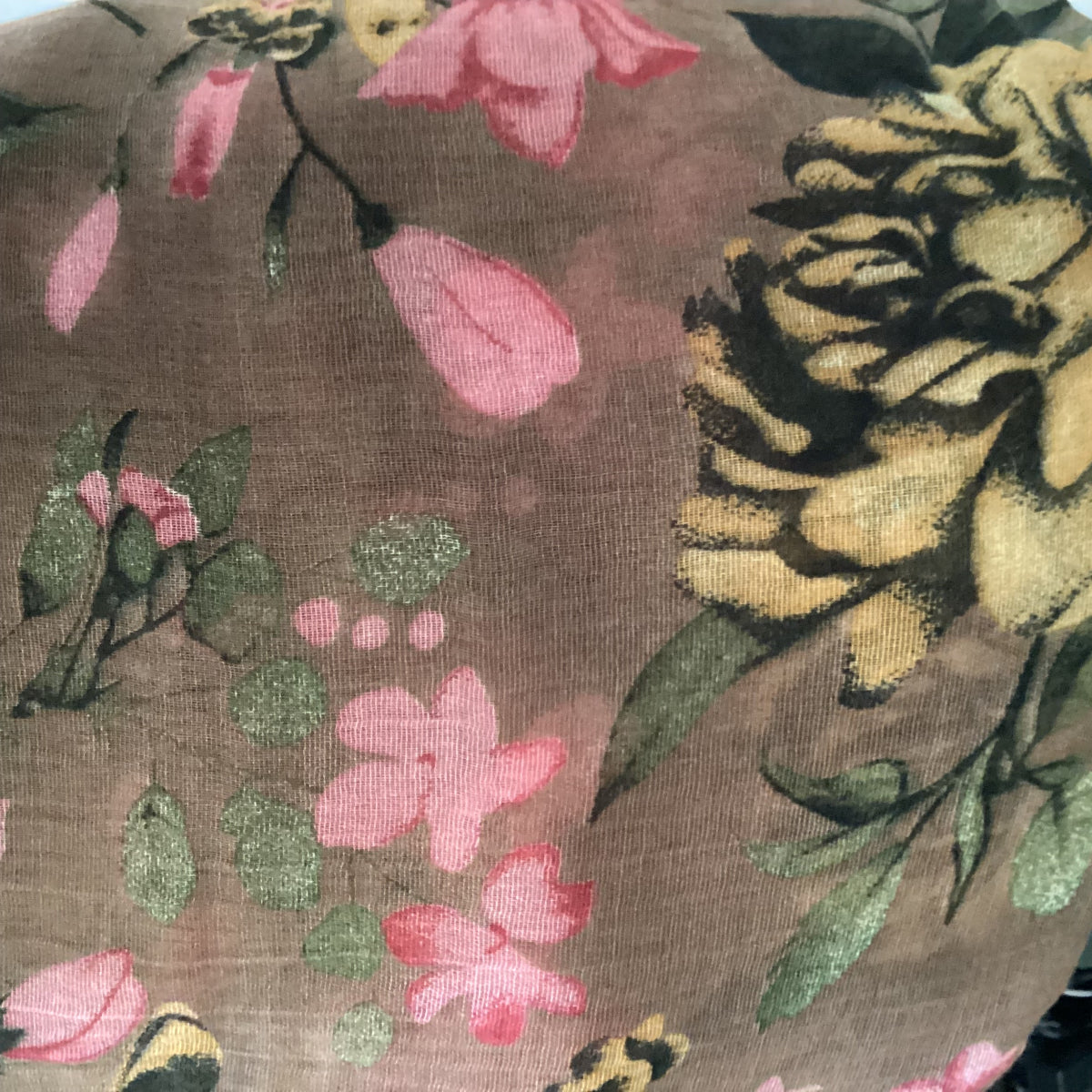 Ac lose up view of a brown scarf with a pink and yellow floral pattern