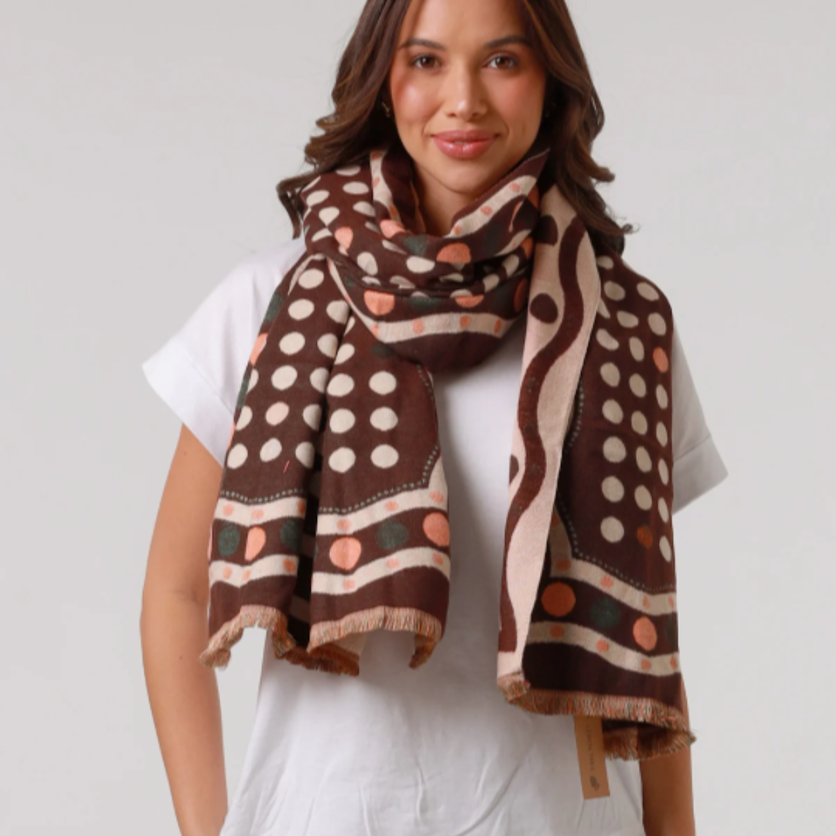 Woman wearing a patterned scarf on a plain background