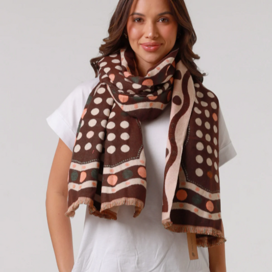 Woman wearing a patterned scarf on a plain background
