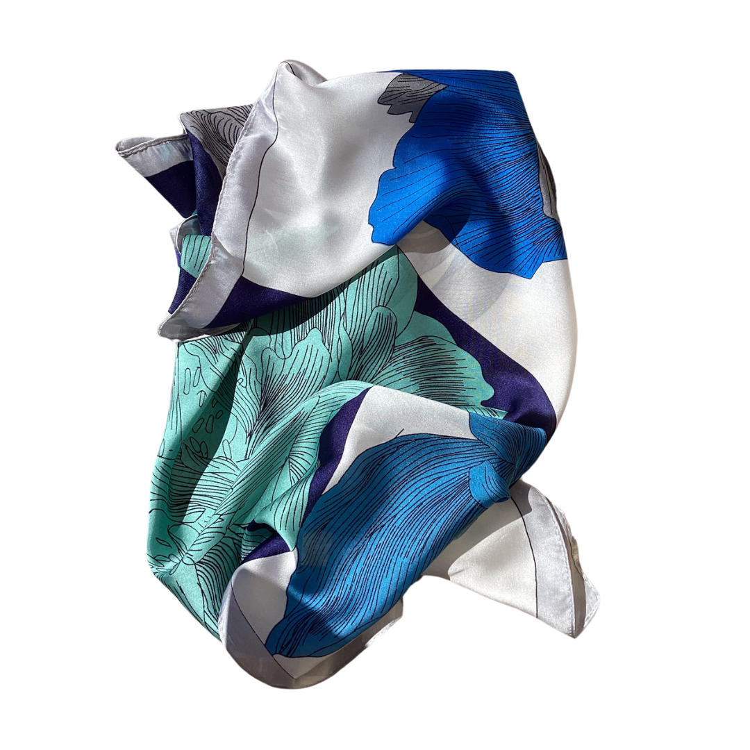 a ladies scarf that has bright blue flowers on a navy or white background and is soft and silky feeling