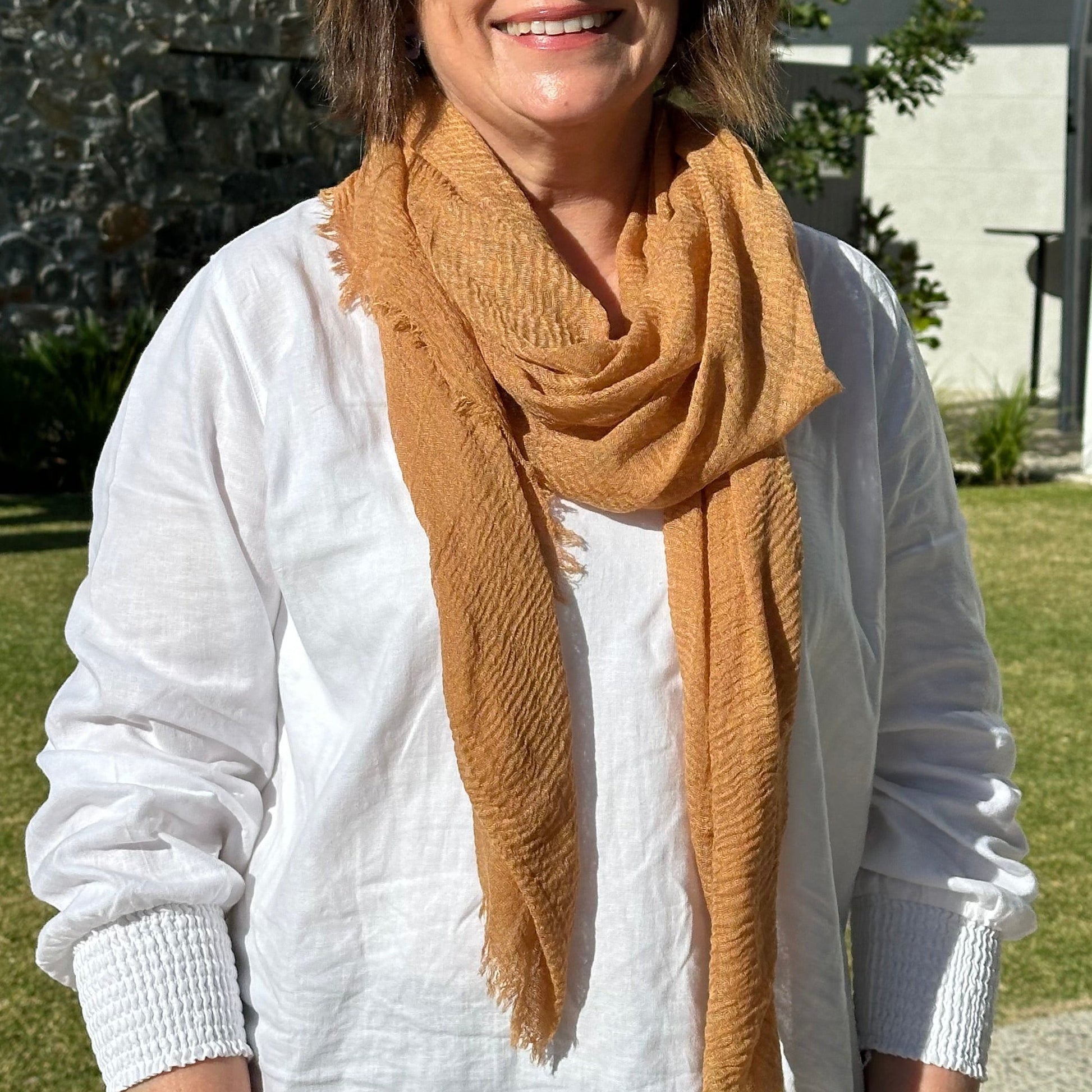 a lady wearing a plain caramel coloured scarf that has a textured weave