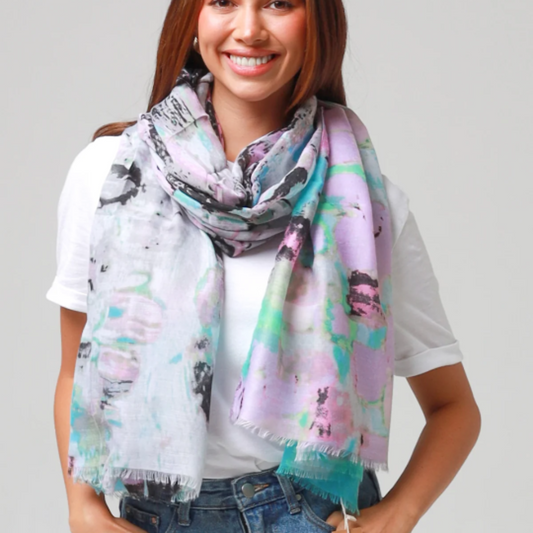 Woman wearing a colorful scarf with abstract patterns on a plain background