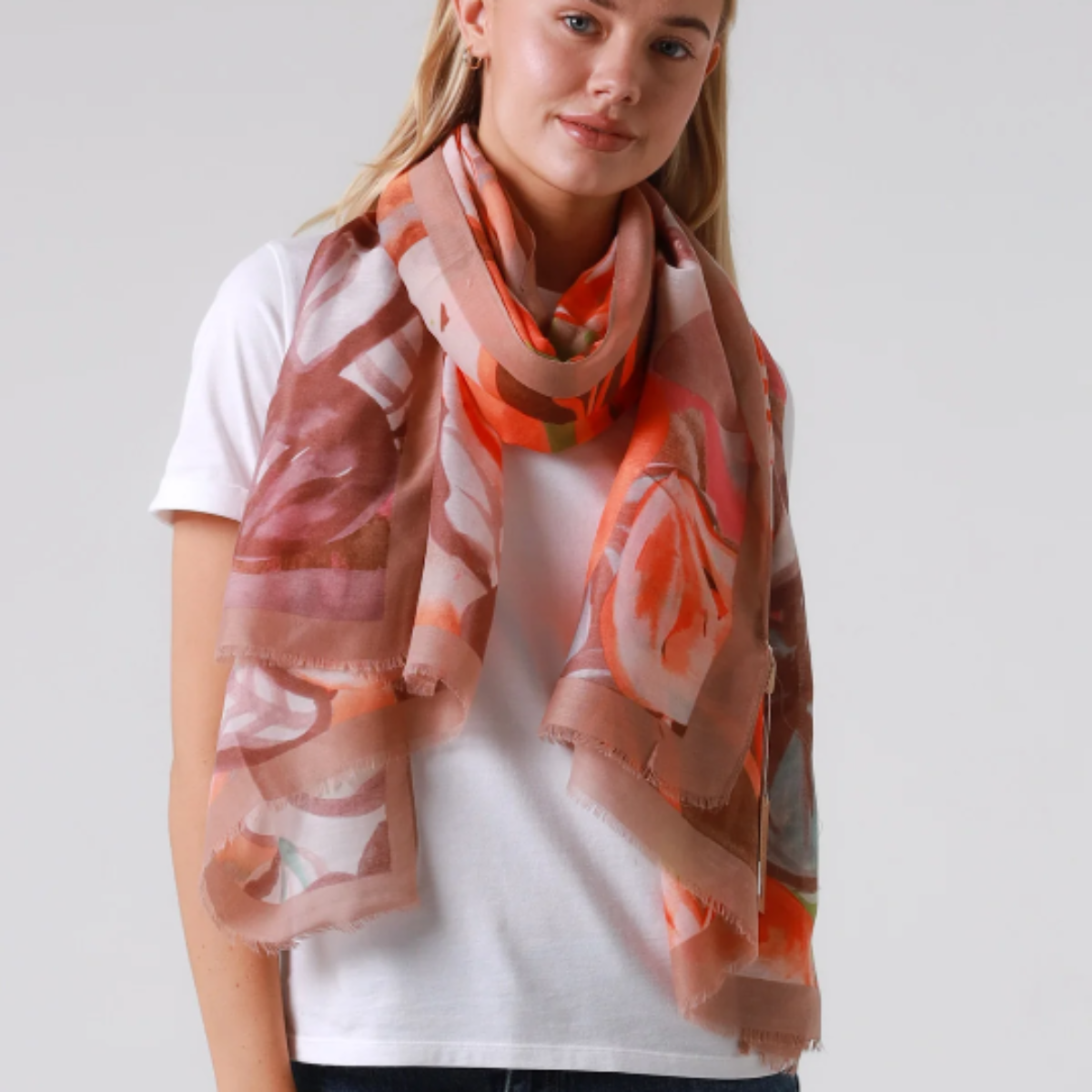 Woman wearing a colorful scarf on a plain background