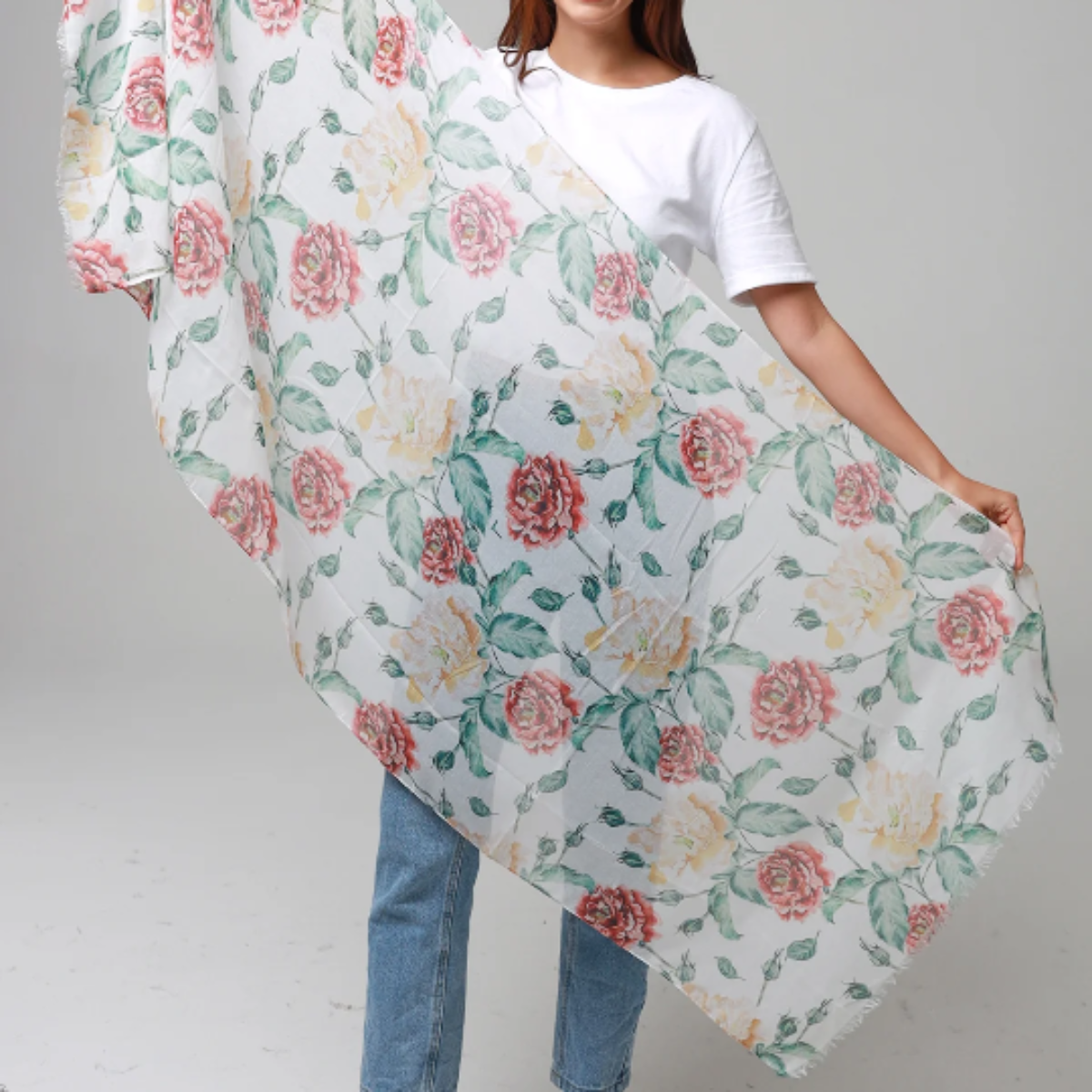 Woman holding a floral-patterned fabric against a gray background
