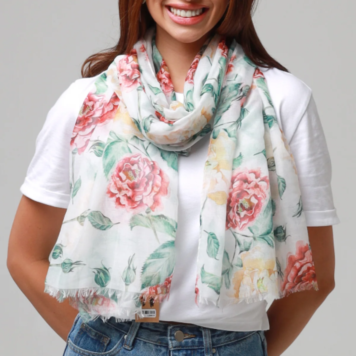 Woman wearing a floral scarf with a plain background