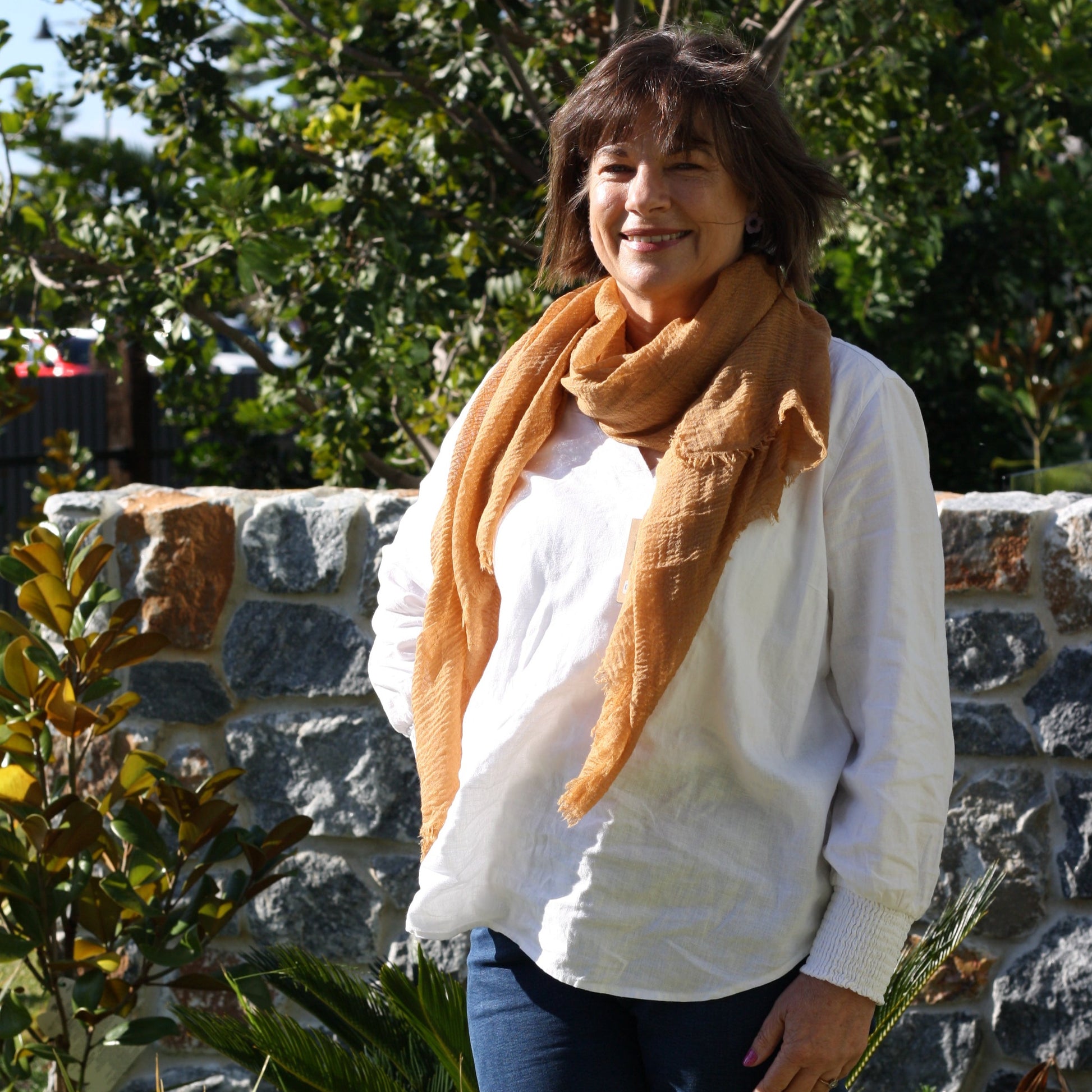 a lady wearing a caramel coloured scarf that has a textured weave