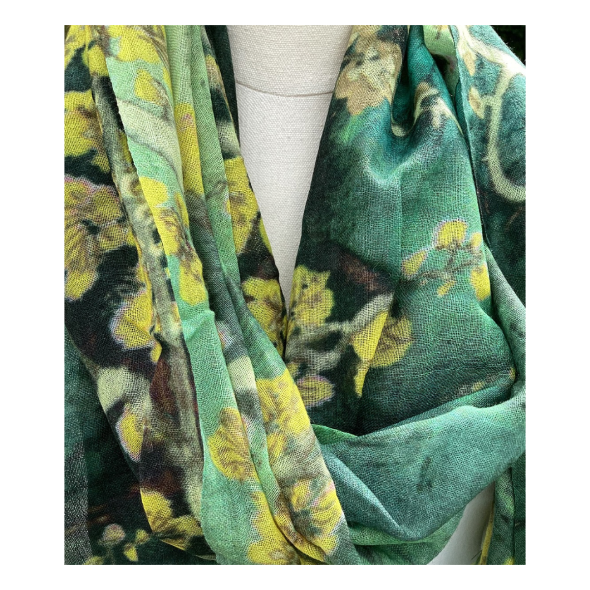 Green floral patterned scarf draped over a mannequin
