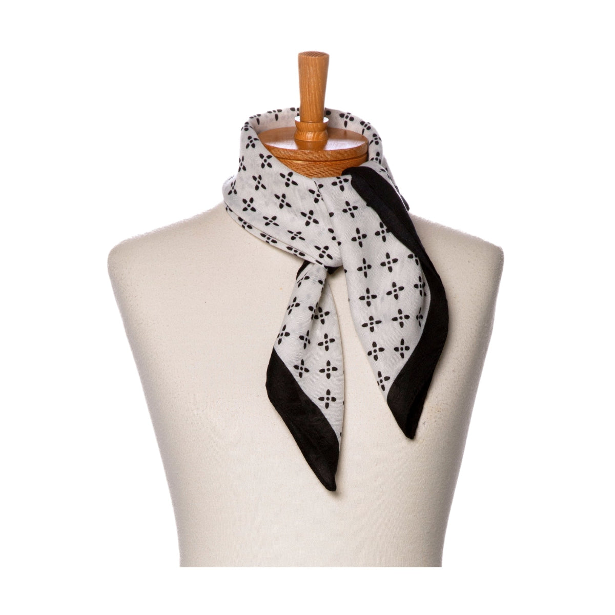 Black and white patterned scarf on a mannequin with a wooden hanger against a white background