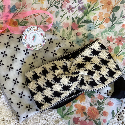 Black and white scarf and knitted headband on a floral tissue paper 