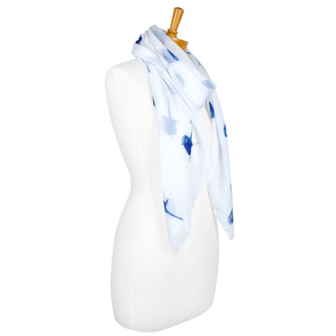 A cotton ladies scarf that has a white background and medium sized blue Splendid Fairy Wrens. The picture shows the pretty scarf draped onto a mannequin and shows the side view.