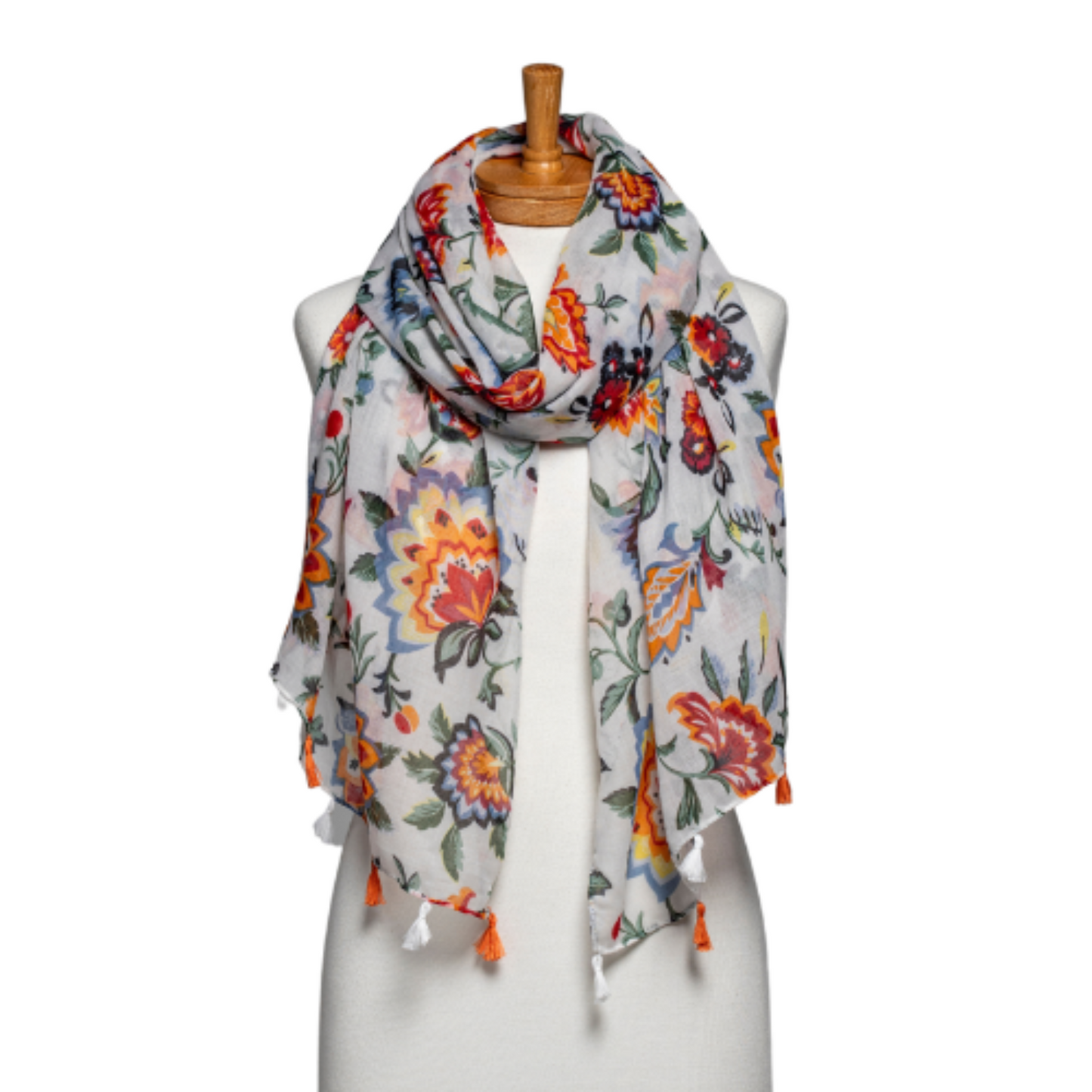 a ladies scarf that has bright red and orange abstract flowers and outlined in denim blue and dark and light green leaves and the scarf is finished with alternating orange and white tassels