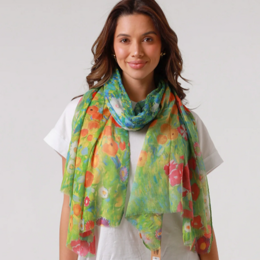 a lady wearing a scarf that has brightly coloured flowers inspired by artist Gustav Klimt