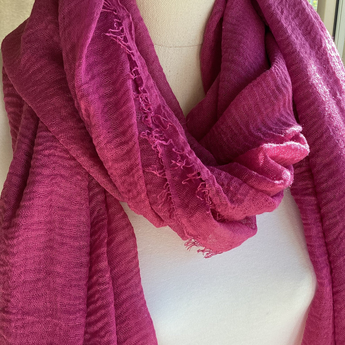 Close-up of a pink scarf on a mannequin with a blurred background