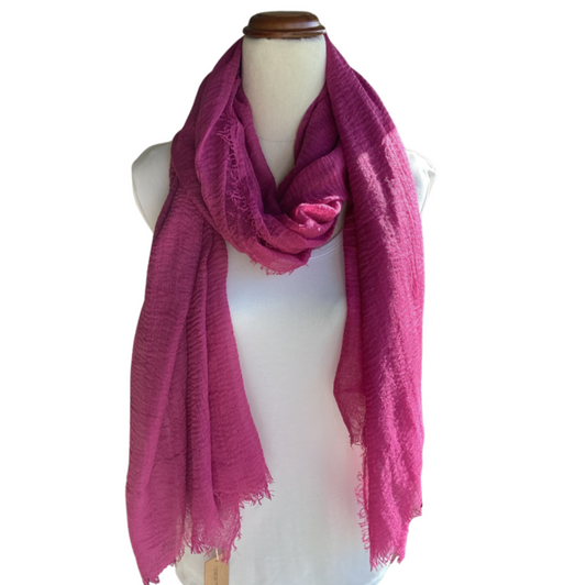 Mannequin wearing a bright pink scarf on a white background