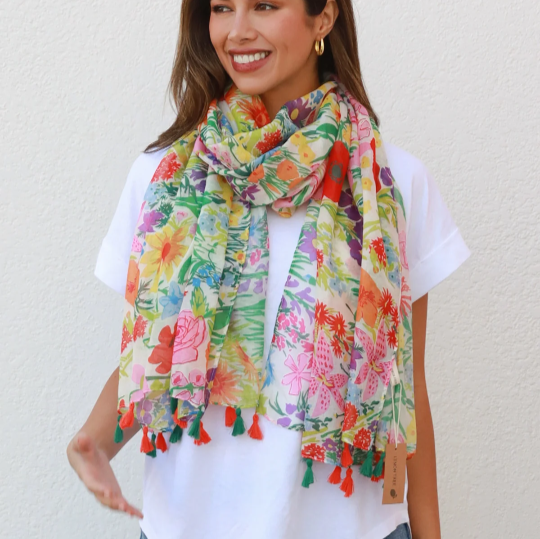 a lady wearing a brightly coloured floral scarf with tassels