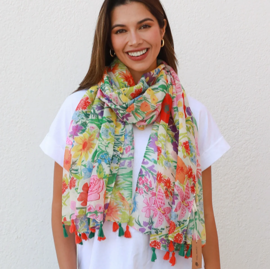 A bright and colourful scarf with an all over floral pattern and finished with alternating red and green tassels