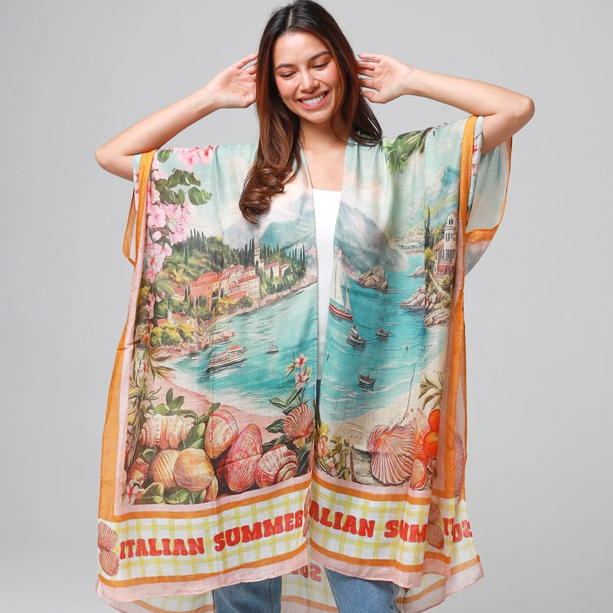 Woman wearing a colorful kimono-style garment with scenic print on a plain background