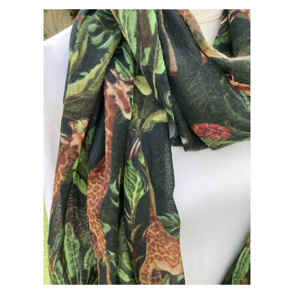 Scarf with giraffe and plant pattern draped over a white surface