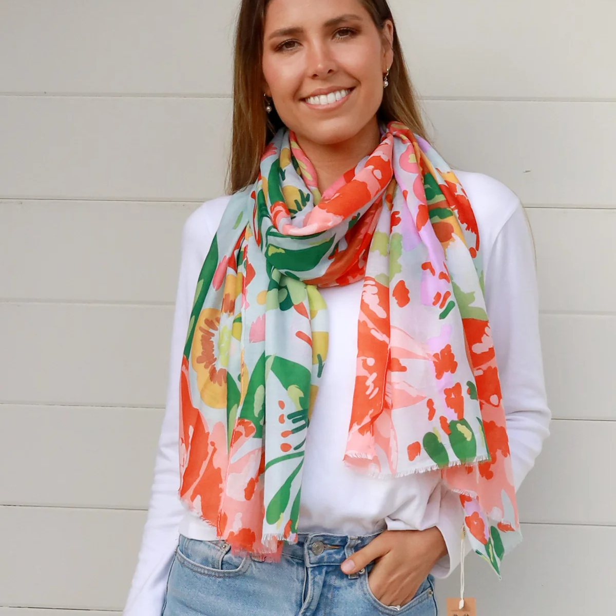 Woman wearing a colorful floral scarf with a white background