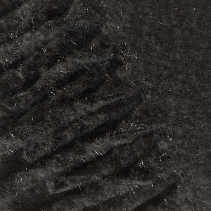 Close-up of textured black knit scarf that has a glitter thread and chunky tassels