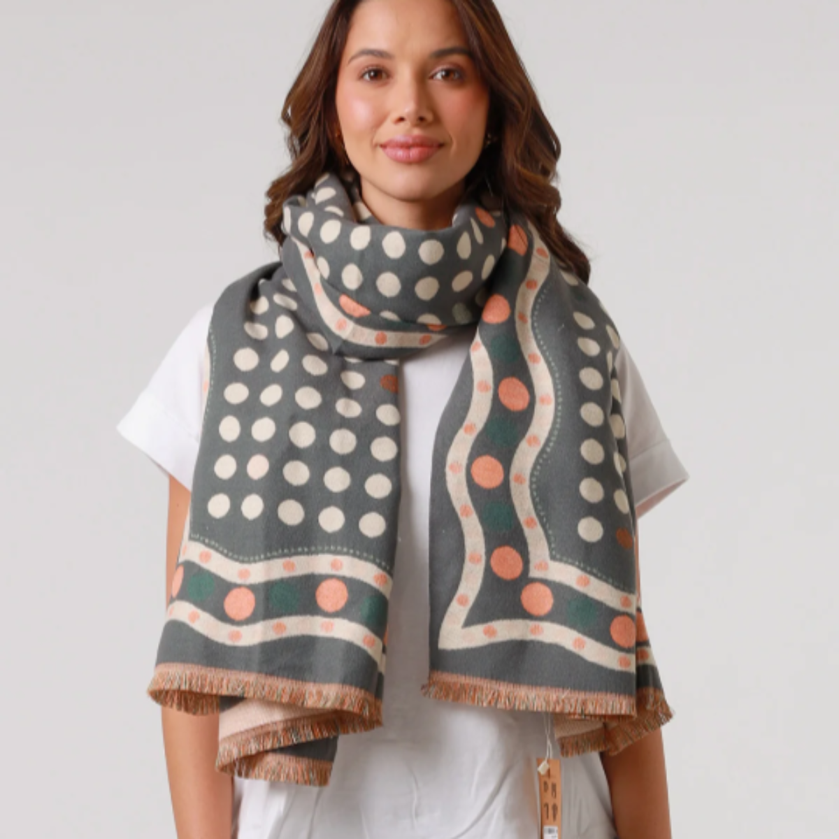 Woman wearing a patterned scarf on a plain background