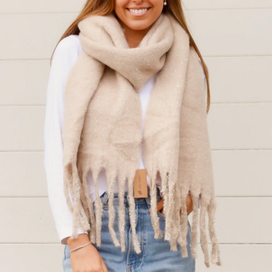 Woman wearing a beige scarf with gold glitter and a white background