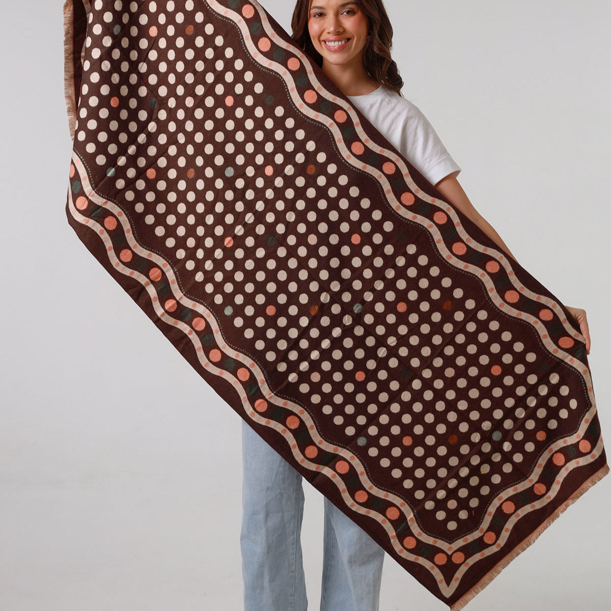 Woman holding a large brown and beige patterned fabric against a white background