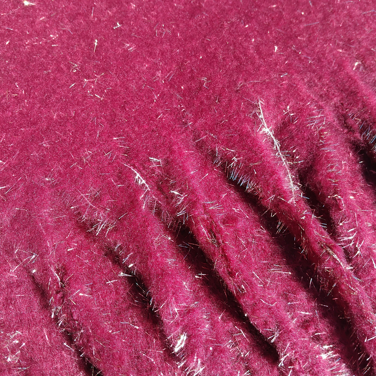 Close-up of a dark red textured ladies winter scarf with gold glitter fibres