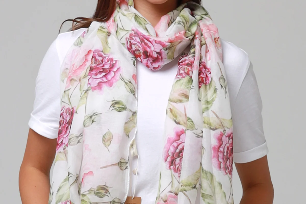 Woman wearing a floral scarf with a plain background