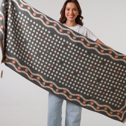 Woman holding a large patterned scarf against a white background