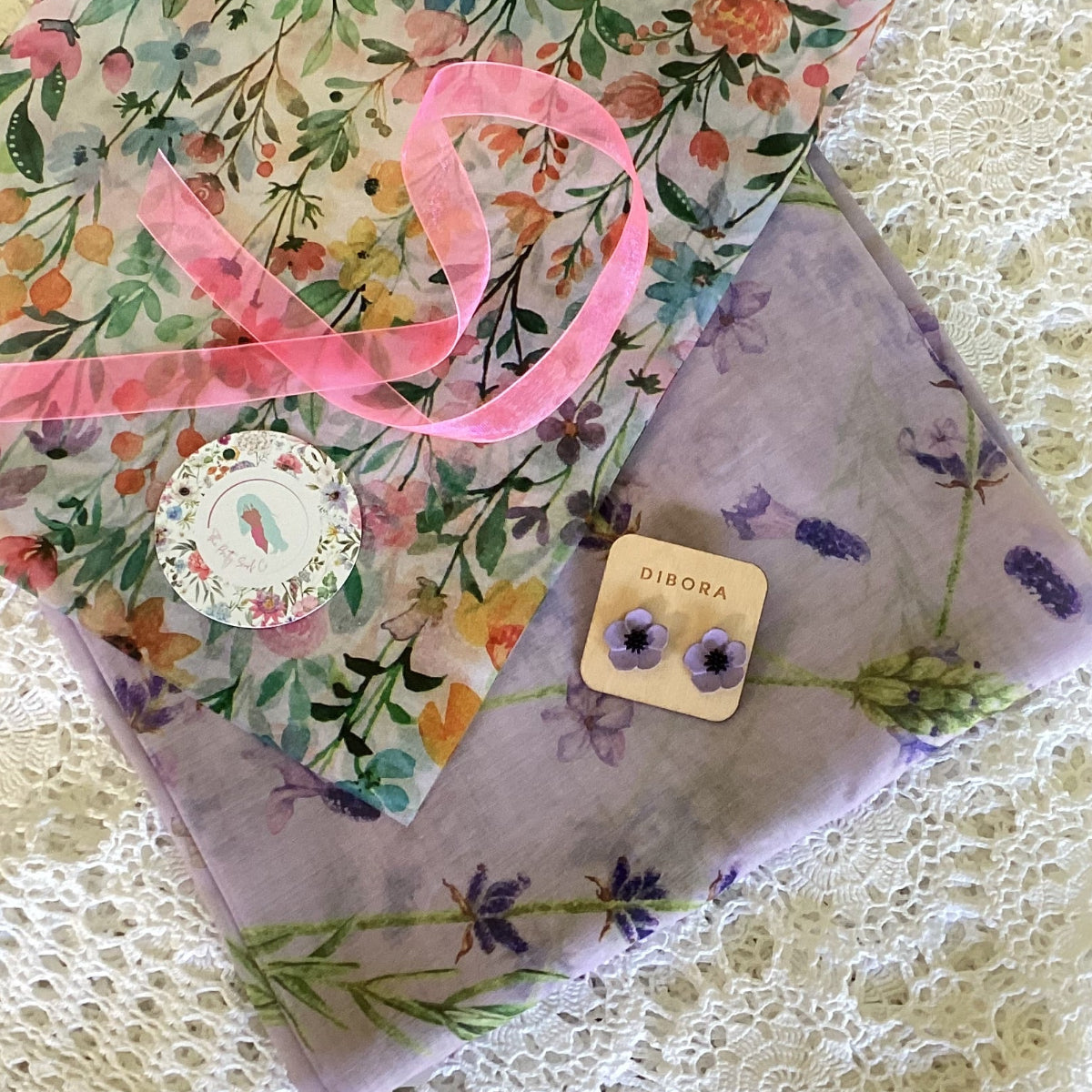 Floral purple scarf with a pair of earrings with floral tissue paper, pink ribbon and a gift tag